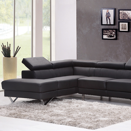 A black sectional couch in the middle of a room.